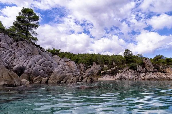 在遮阳伞和、 chalkidiki、 希腊，在多云的天空下的岩石海岸 — 图库照片