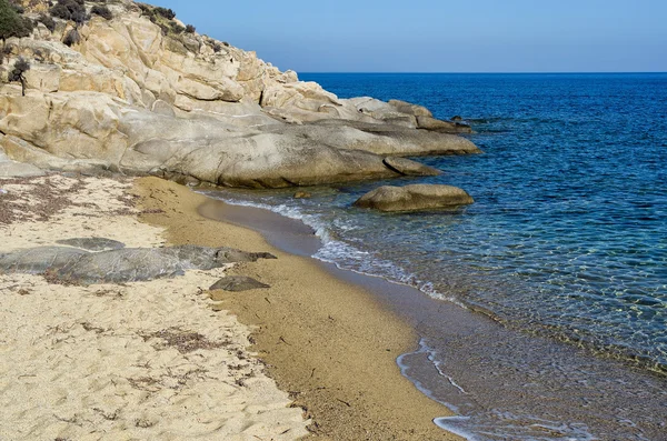 Felsen in einem Sandstrand in Sithonia, Chalkidiki, Griechenland, mit kristallklarem Wasser — Stockfoto