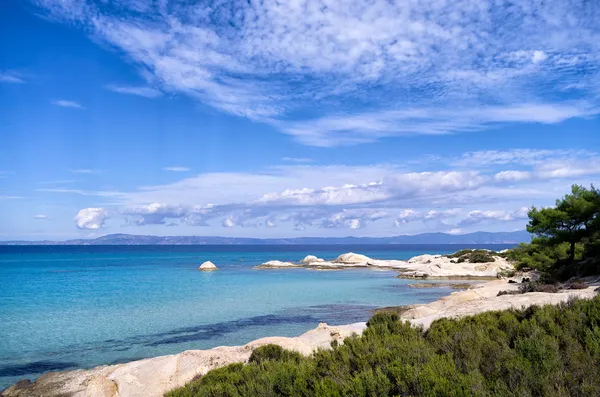 小的沙质海湾，在遮阳伞和、 chalkidiki、 希腊和外来水的岩石海岸 — 图库照片