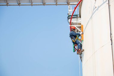 Erkek işçi halat erişim denetimi Kalınlık depolama tankı endüstrisi.