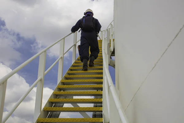 階段の上を歩く男性青い空の上の視覚記録タンクの階段 — ストック写真