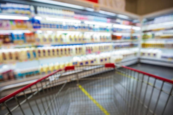 Defocused blur of supermarket shelves with dairy products. Blur background with bokeh. Defocused image