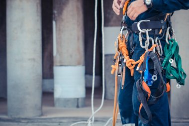 Closeup Male worker standing on tank bottom  before working safety on rope access of inspection storage tank clipart