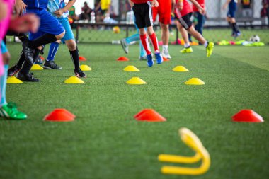 Arka planda Tayland eğitimi için koni ile çim sahası üzerinde futbol taktikleri Futbol akademisinde çocukları eğitmek