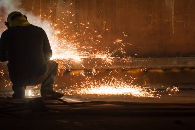 Koruyucu giysiler giyen ve kapalı alanlarda depolama kaplaması yangını ve dumanı tamir eden erkek işçiler.