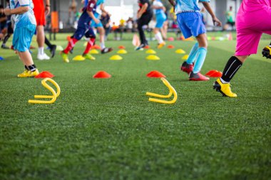 Arka planda Tayland eğitimi için koni ile çim sahası üzerinde futbol taktikleri Futbol akademisinde çocukları eğitmek