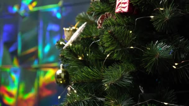 在明亮的背景下 闪烁着模糊的节日彩灯 男人用红色金球装饰人造圣诞树的特写镜头 圣诞摘要4K视频背景 — 图库视频影像