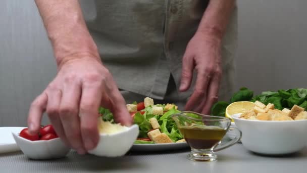 一位男性厨师准备了一份健康可口的素食凯撒沙拉 厨师在沙拉上撒上意大利芝士 慢动作一步一步的视频指令 第4步 — 图库视频影像