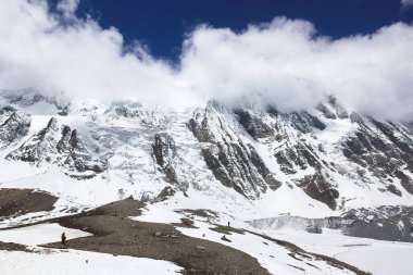 Mavi gökyüzüne karşı beyaz bulutlu karlı dağlar. Nepal Dağları.