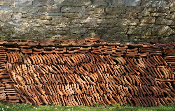 Ev duvarında yığılmış çatı kiremitleri