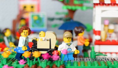 Lego figürlü anne ve bebek arabasında. Parkta yürümenin ya da anneler günü tatilinin editoryal tasviri.