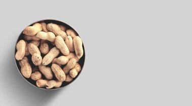 Seramik kaseye eklenmiş üstteki fıstıkların yakın fotoğrafını çek, fındıklı çiğ fıstıklar gri arka planda izole edilmiş..