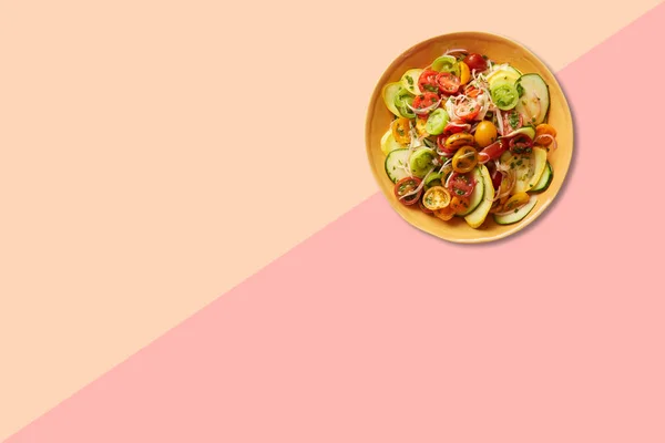 用粉红色背景隔离的褐色盘子把蔬菜沙拉关起来 — 图库照片