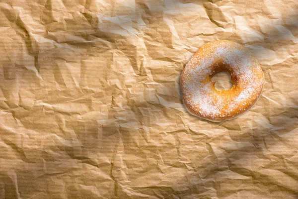 Fresh homemade donuts with sugar powder on baking paper. American bakery concept.