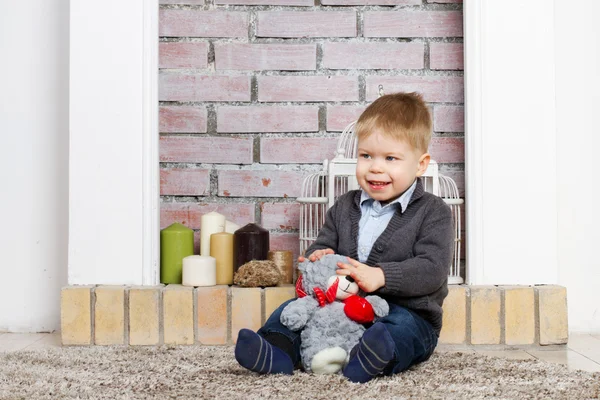 Kleine jongen zit op een vloer — Stockfoto