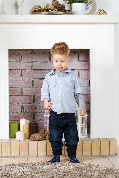 Kleine jongen bij een open haard — Stockfoto