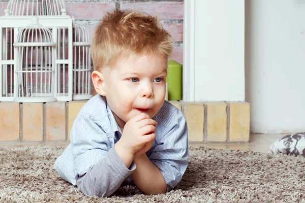 Pequeño niño se encuentra en una alfombra — Foto de Stock