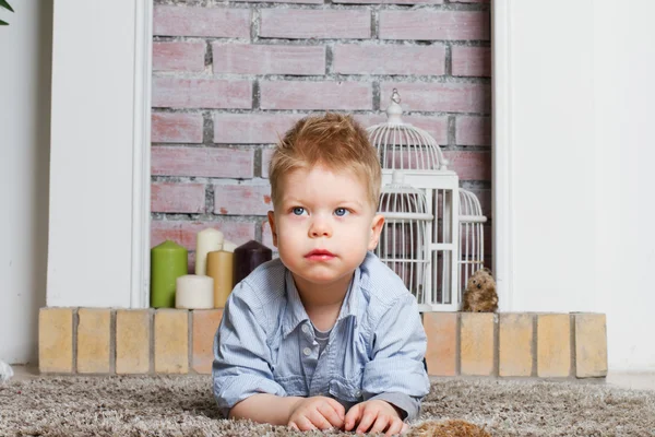 Kleine jongen ligt op een tapijt — Stockfoto