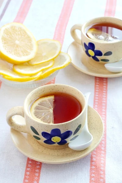 Duas xícaras de chá preto com limão — Fotografia de Stock