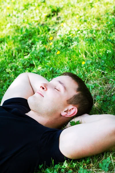 Молодой человек отдыхает на траве — стоковое фото