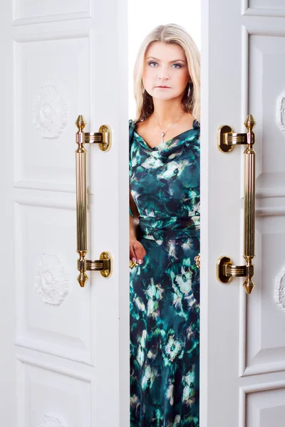 Jonge vrouw komt uit de deur — Stockfoto