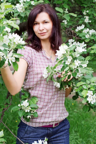 Joven mujer feliz en un jardín floreciente —  Fotos de Stock