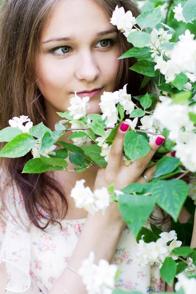 Porträtt av den unga kvinnan i en blommande trädgård — Stockfoto