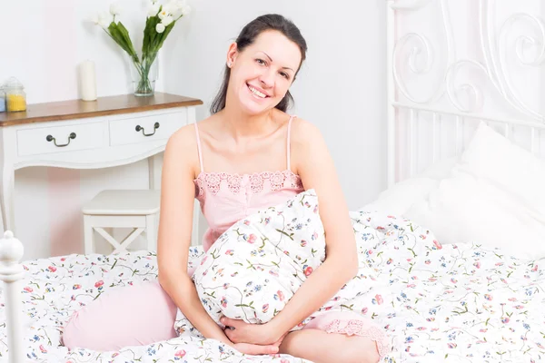 Mujer joven acostada en la cama — Foto de Stock