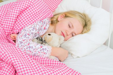 Küçük kız yatakta uyuyor.
