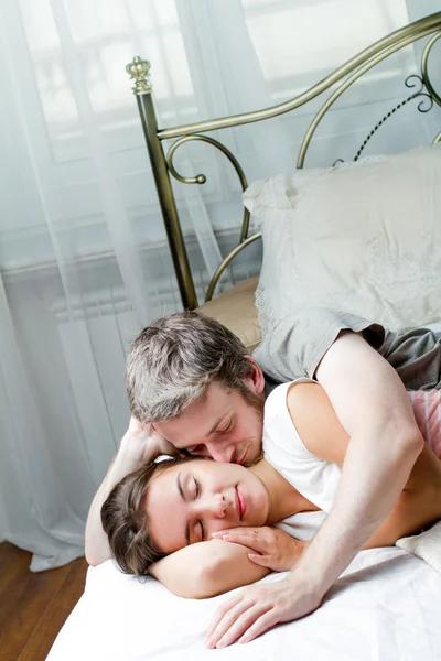 Çift, genç bir adam ve kadın yatakta. — Stok fotoğraf