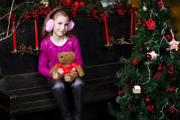 Menina sentada perto da árvore de Natal — Fotografia de Stock