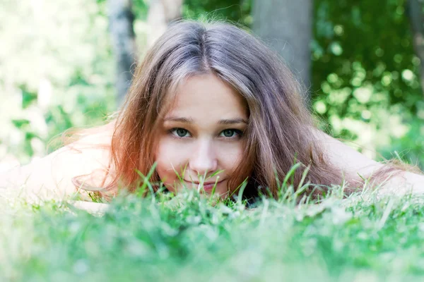 Vacker flicka liggande på gräset — Stockfoto