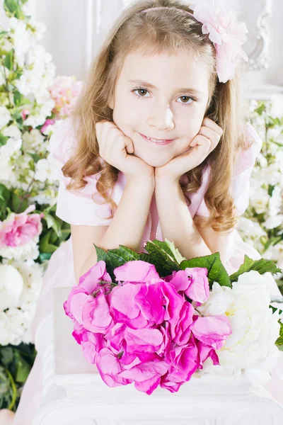 Pequena menina bonito com flores — Fotografia de Stock