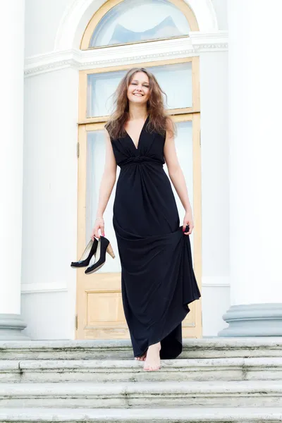 Uzun siyah elbise giymiş genç kadın — Stok fotoğraf