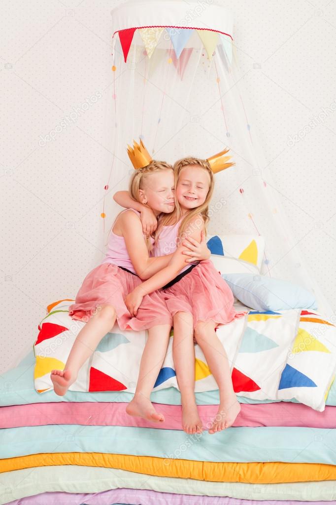 Two little girl lying on a pile of mattresses