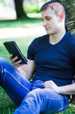 genç adam yere oturuyor ve kitap okuma