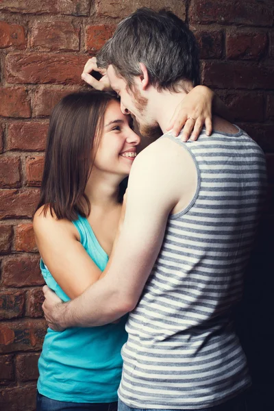 Couple heureux contre un mur de briques — Photo