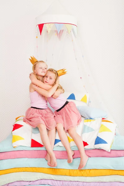 Dvě malá holčička na hromadě matrací. — Stock fotografie