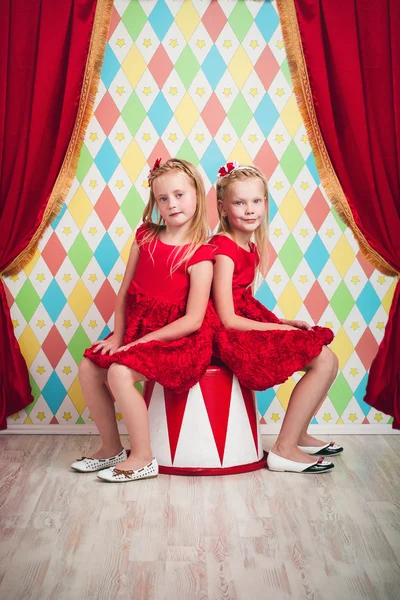 Two little girls in red dresses — Stock Photo, Image