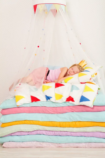 küçük kız minder yığını üzerinde yalan