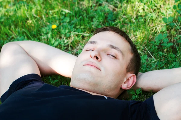 Jonge man ontspannen op het gras — Stockfoto