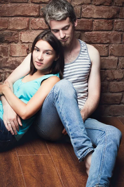 Young couple sitting on the floor — Stock Photo, Image