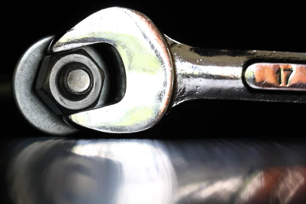 Wrench tighten the nut on black background — Stock Photo, Image
