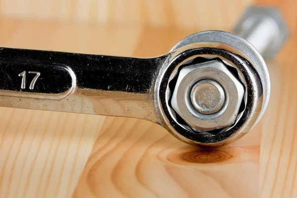 Wrench tighten the nut on wood backgroung — Stock Photo, Image