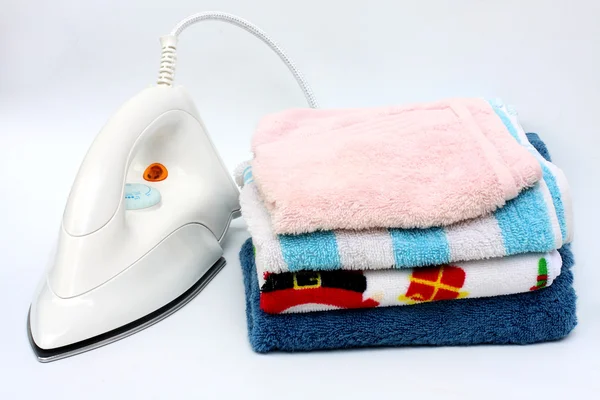 Pile of colorful clothes and electric iron on white background — Stock Photo, Image