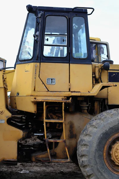 Loader grävskopa med traktorgrävare lossning sand på eathmoving fungerar — Stockfoto