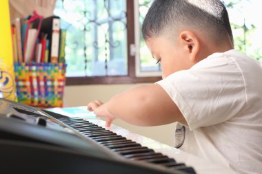 kleine jongen speelt piano plezier