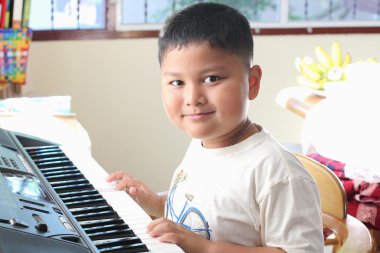 kleine jongen speelt piano plezier