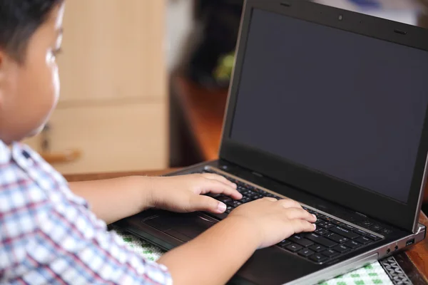 The boy was playing with my notebook. — Stock Photo, Image