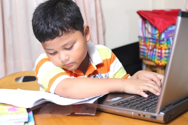 Azjatycki chłopiec pracę domową starannie. — Zdjęcie stockowe